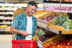 Smiling man choosing pineapple