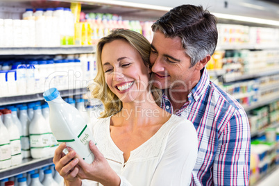 Happy couple holding milk and smiling