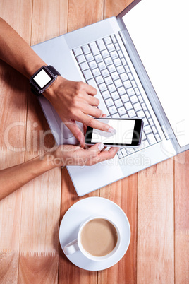 Woman with smartwatch using smartphone