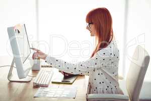 Smiling hipster woman using graphics tablet and pointing screen