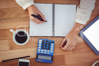 Cropped image of woman writing on notepad