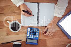 Cropped image of woman writing on notepad