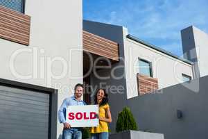 Happy couple in front of new house