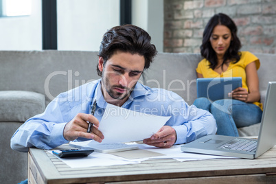 Serious man paying bills in living room