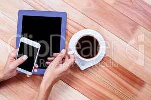 Businesswoman holding smartphone and coffee cup