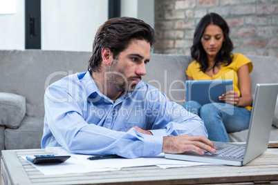 Serious man paying bills in living room