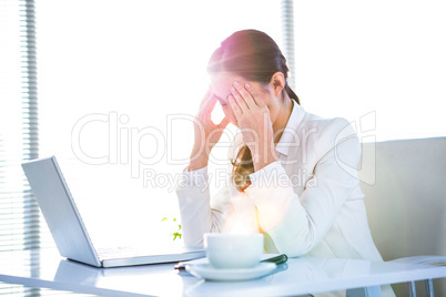 Worried businesswoman holding her head