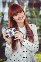 Attractive smiling hipster woman with old fashioned camera