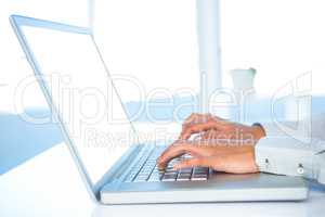 Cropped image of woman using laptop