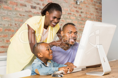 Casual smiling family on a computer