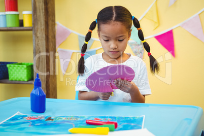 Focused girl cutting a paper plate
