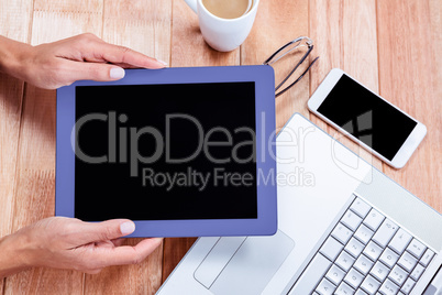 Overhead of feminine hands holding tablet