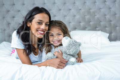 Happy mother and daughter laying o the bed