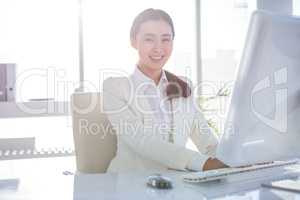 Smiling businesswoman using her computer