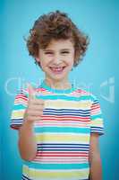 Smiling boy standing with thumbs up