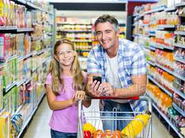 Smiling father and daughter at the supermarket