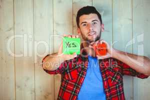Handsome hipster showing yes and no cards