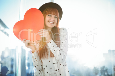 Attractive hipster woman behind a red heart