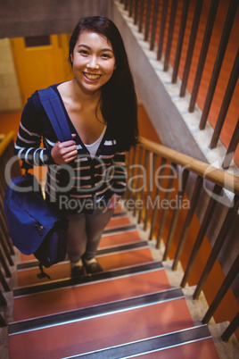 Smiling student walking up steps