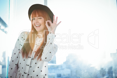 Smiling hipster woman making ok sign