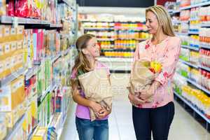 Smiling mother and daughter with grocery bags