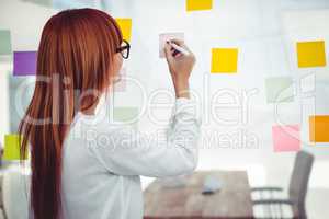 Attractive hipster woman writing on sticky notes