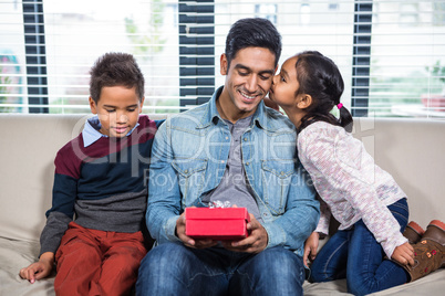 Happy father receiving a gift from his children