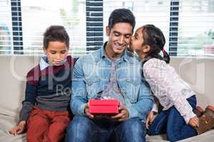 Happy father receiving a gift from his children