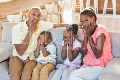 Portrait of a family of four watching tv