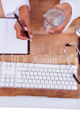 Doctor holding pen and glass of water