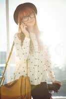 Smiling hipster woman having a phone call