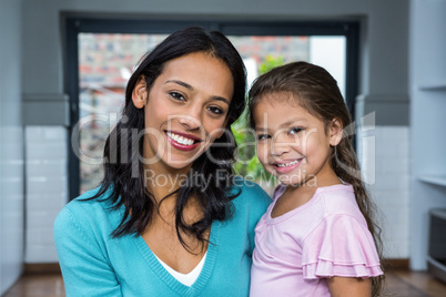 Smiling mother and daughter in living room