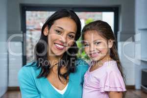 Smiling mother and daughter in living room