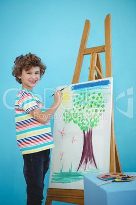 Happy boy painting his picture