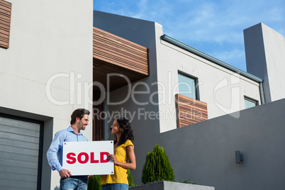 Happy couple in front of new house