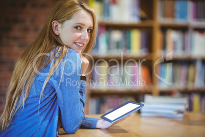 Student with smartwatch using tablet in library