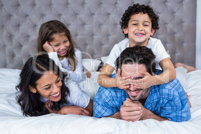 Smiling family laying on the bed