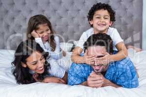 Smiling family laying on the bed