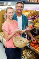 Happy couple holding tomatoes