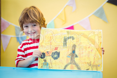 Smiling child holding up his finished painting