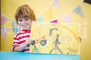 Smiling child holding up his finished painting