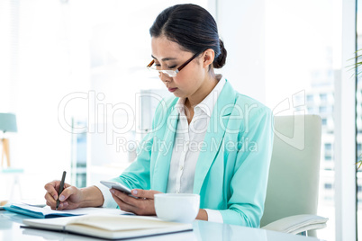 Smiling businesswoman using her smart phone