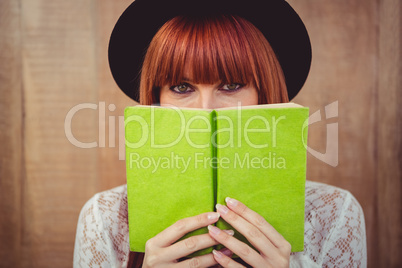 Hipster woman behind a book