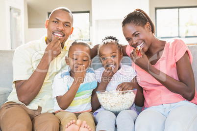 Portrait of a family of four watching tv