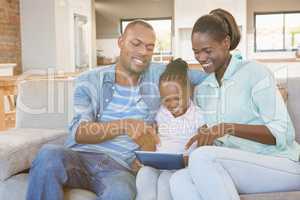 Parents watching daughter using tablet pc