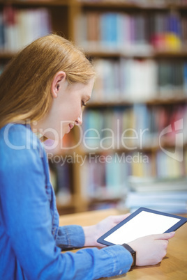 Student with smartwatch using tablet in library