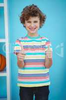 Smiling boy standing with thumbs up