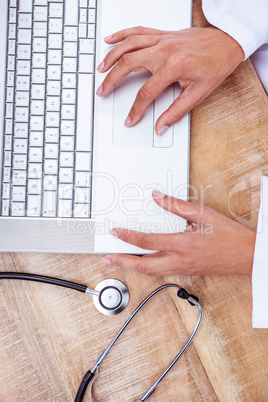 Doctor using laptop on wood desk