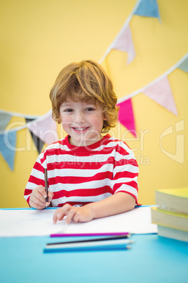 Boy using a pencil to write on paper