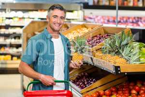 Smiling man choosing pineapple